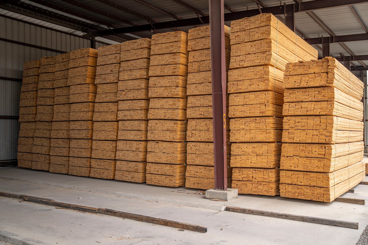 Madera apilada en almacén cubierto de serrería industrial