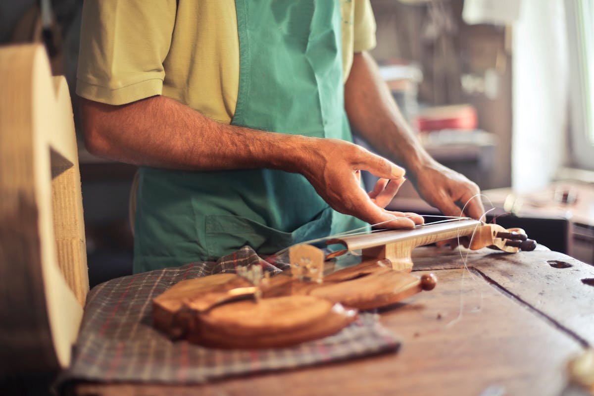 Luthier construyendo un violín en taller artesanal — nicho de instrumentos musicales