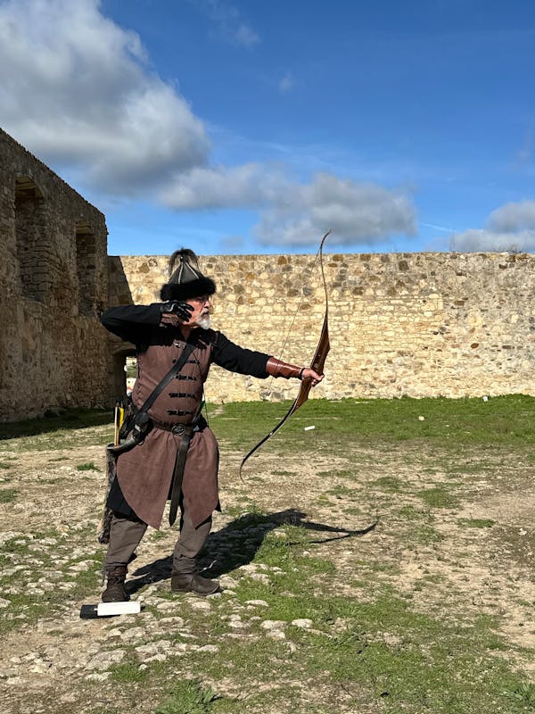 Arquero medieval con arco de madera en castillo