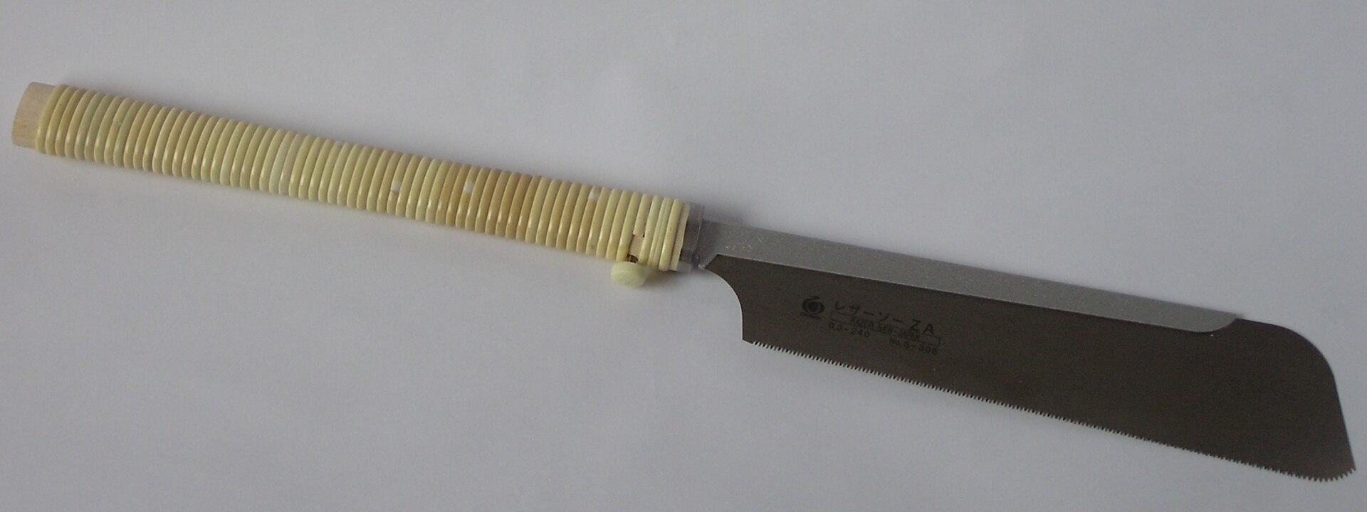 Detalle de la hoja y el lomo rígido de una sierra dozuki japonesa